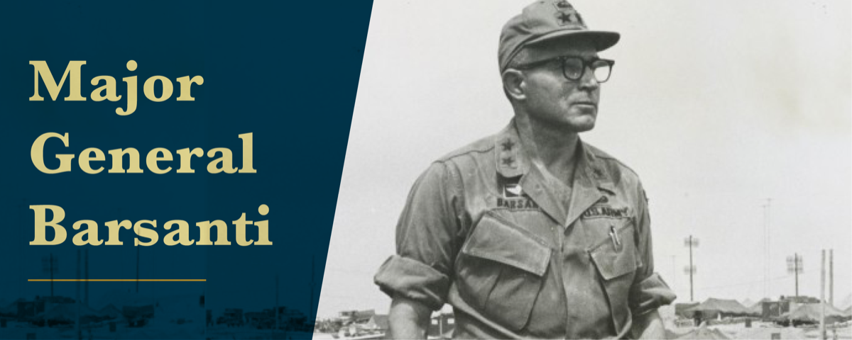 The banner is a black and white photograph of Barsanti, a young man in his army uniform with black glasses, some of the buildings can be seen in the background. On the left side over the photo is a blue background with the words Major General Barsanti in tan letters over it and a yellow line under the last word.
