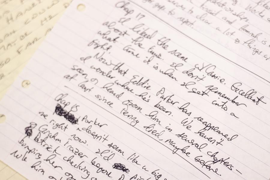 A close up of a sheet of notebook paper with handwriting on it in pen and cursive letters.