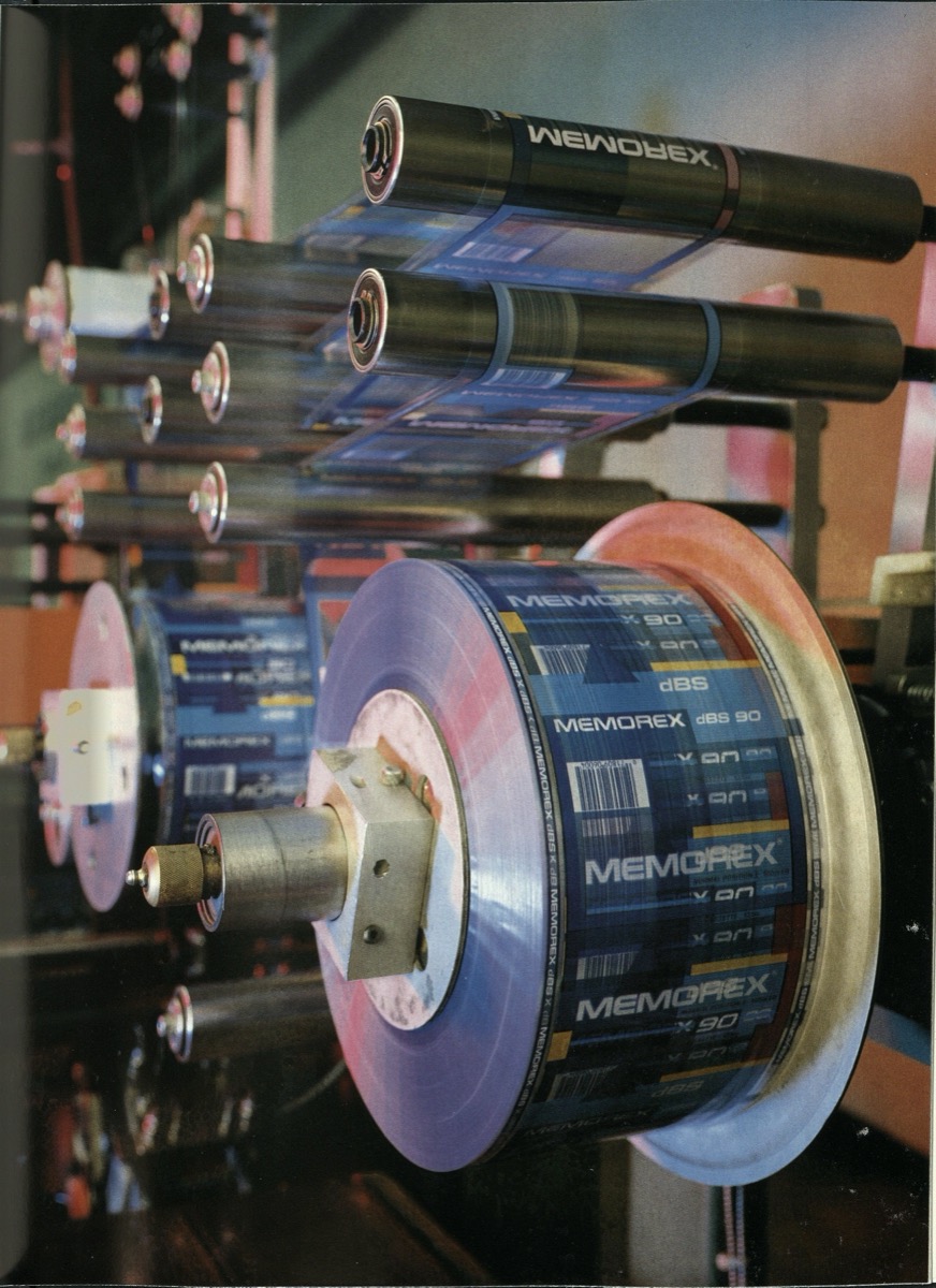 Photograph of the side view of several rolls of brochure papers with the word Memorex on it.