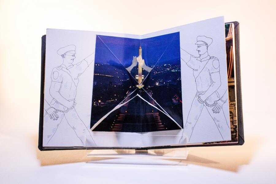 Book open, a photo of a city at night in between both pages. On the left and right sides are drawings of a soldier.