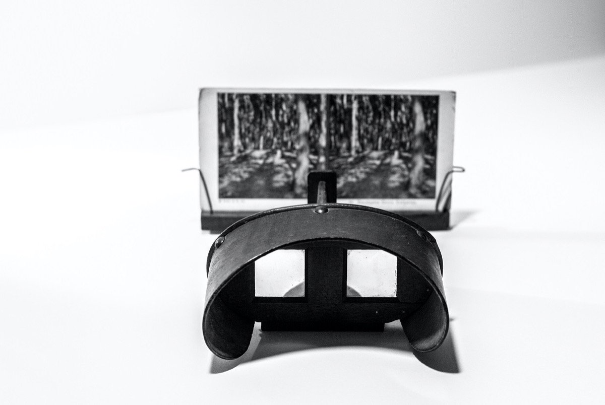 A black stereoscope viewer, a photo on display on it. Black and white.