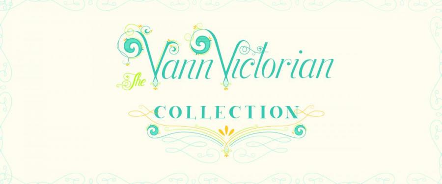White banner with exhibit name, The Vann Victorian Collection in the middle in script letters, the letters are blue. The frame of the banner is lined with blue curved lines.